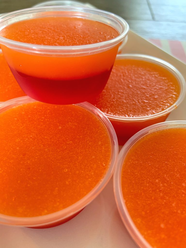 close up of tequila sunrise jello shots with orange and red layers